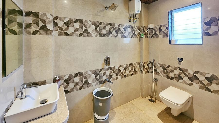 Bathroom of Triple Premium Room at The Kanila Resort featuring a toilet, sink area and a bucket.