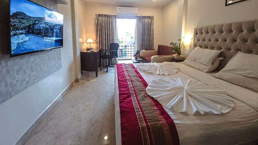 A bright room with an elegant bed, seating area, and access to a balcony – The Verda de Miranda Resort.