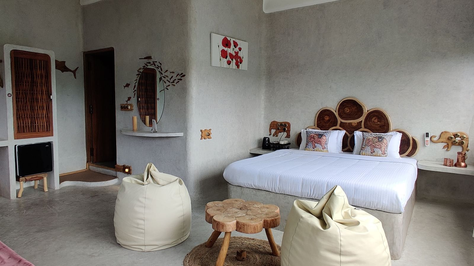 Marlin-6 - comfy bed accompanied by luxorious bean bags and a tea table, with the background in white painted walls.
