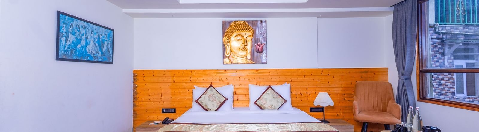 Elegant bedroom at Sumitel Premier Inn, Siliguri, designed with wooden flooring, soft lighting, and a cosy bed offering a peaceful and welcoming ambience.