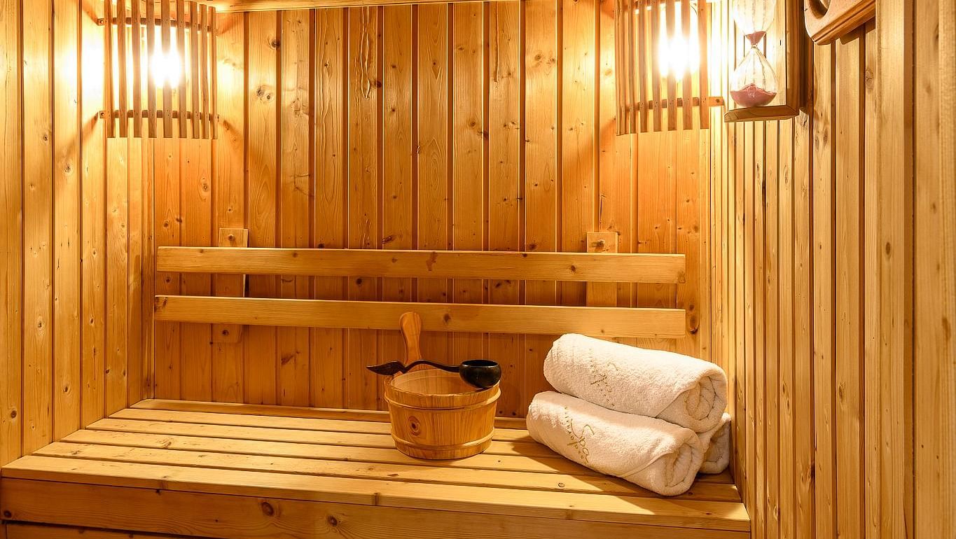 The sauna made out of wood, with warm light and rolled towels - Maikhao Dream Villa Resort & Spa, Phuket