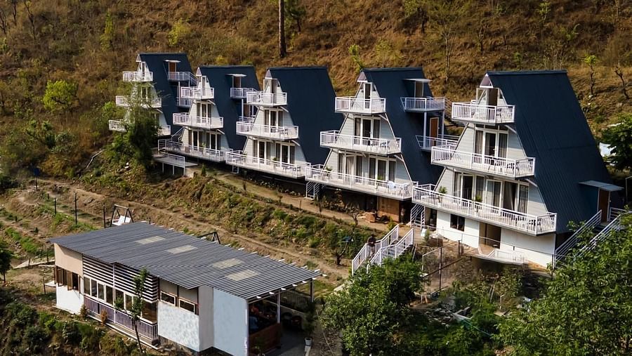 An aerial daytime view of a resort complex with multiple buildings set into a hillside landscape.