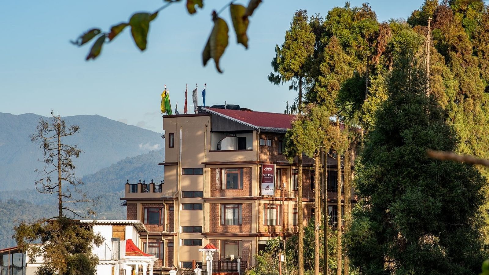 Facade of Summit Sherpa Mountain Hotel & Spa, Kalimpong with a mountain range in the background