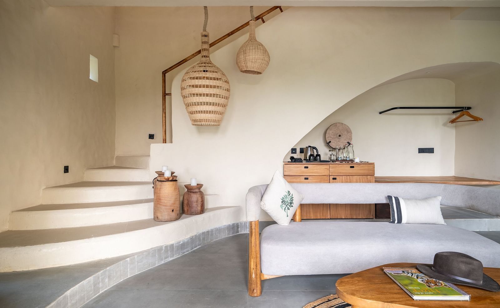 Interior view of a rustic-style living area with hanging woven lights and wooden furniture.