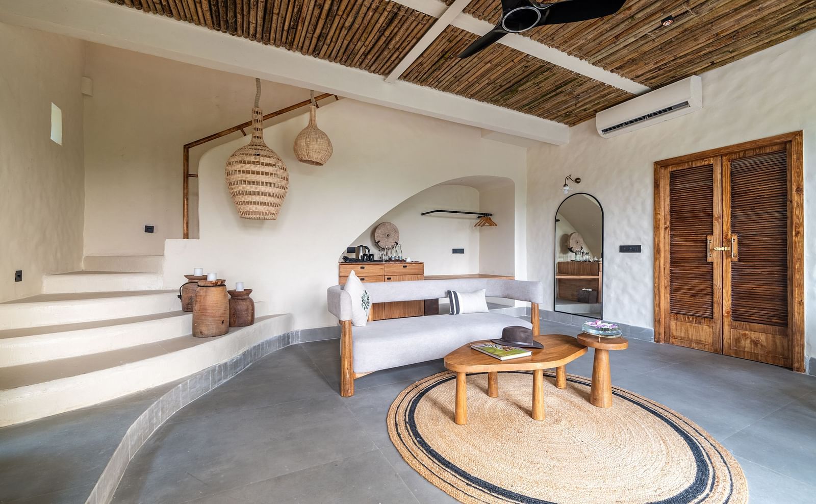 Interior view of a rustic-style living area with hanging woven lights and wooden furniture.