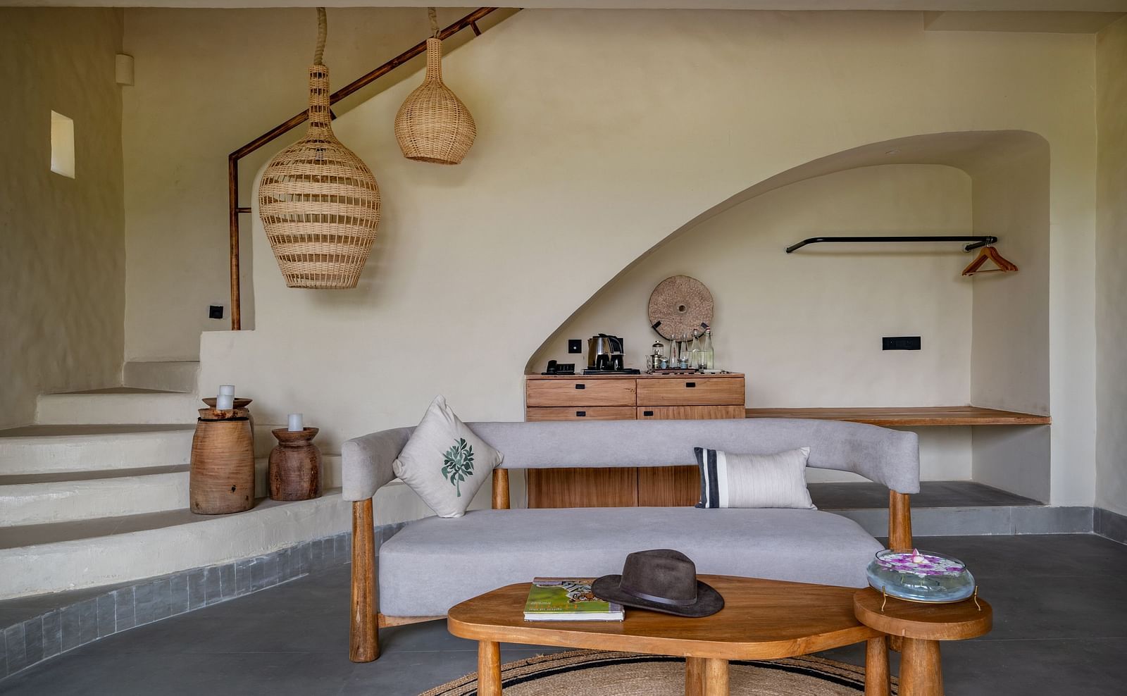 Spacious living room with large windows, woven pendant lights, and earthy decor.