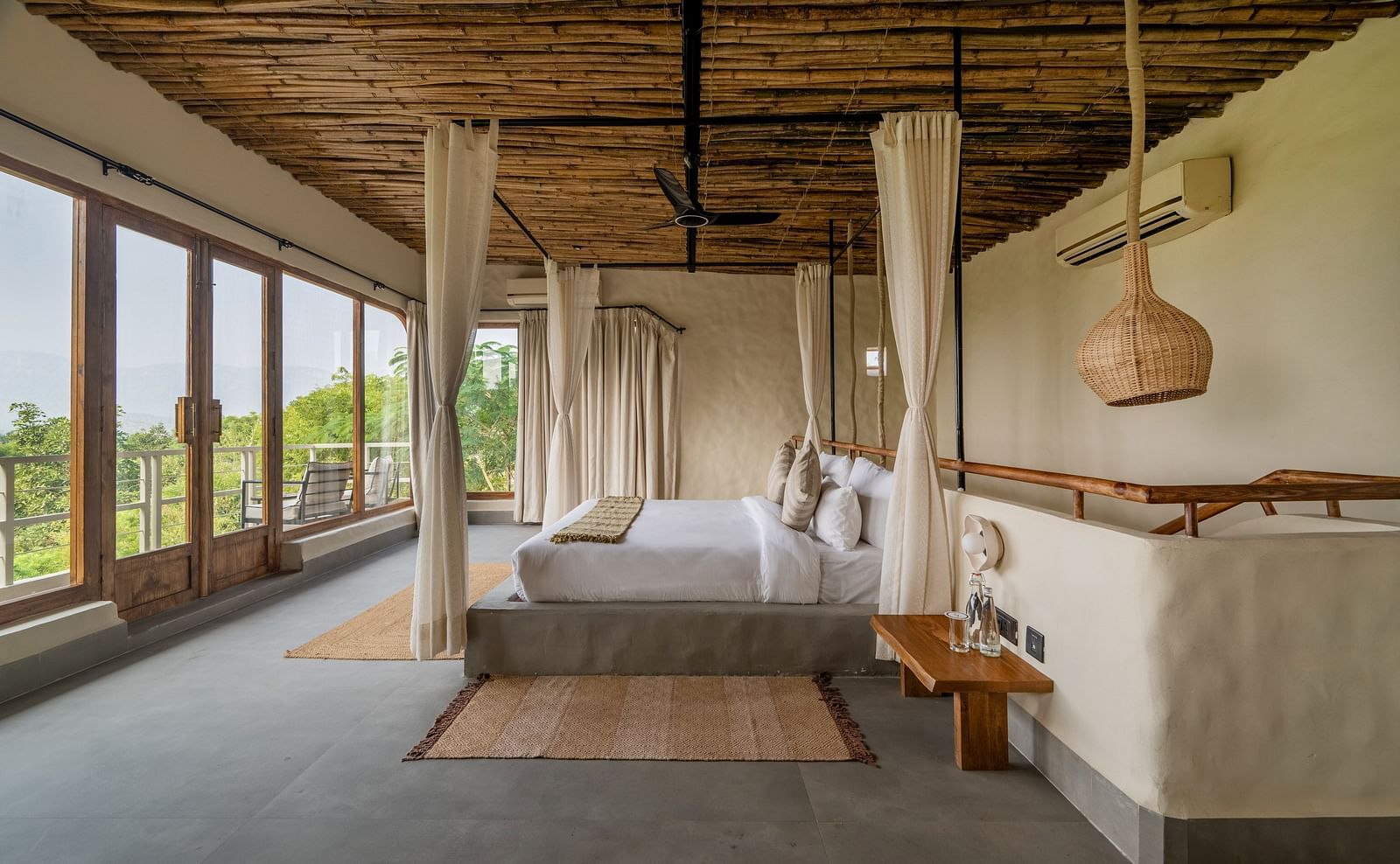 Bedroom with canopy bed, wooden ceiling, and large windows opening to a scenic view.