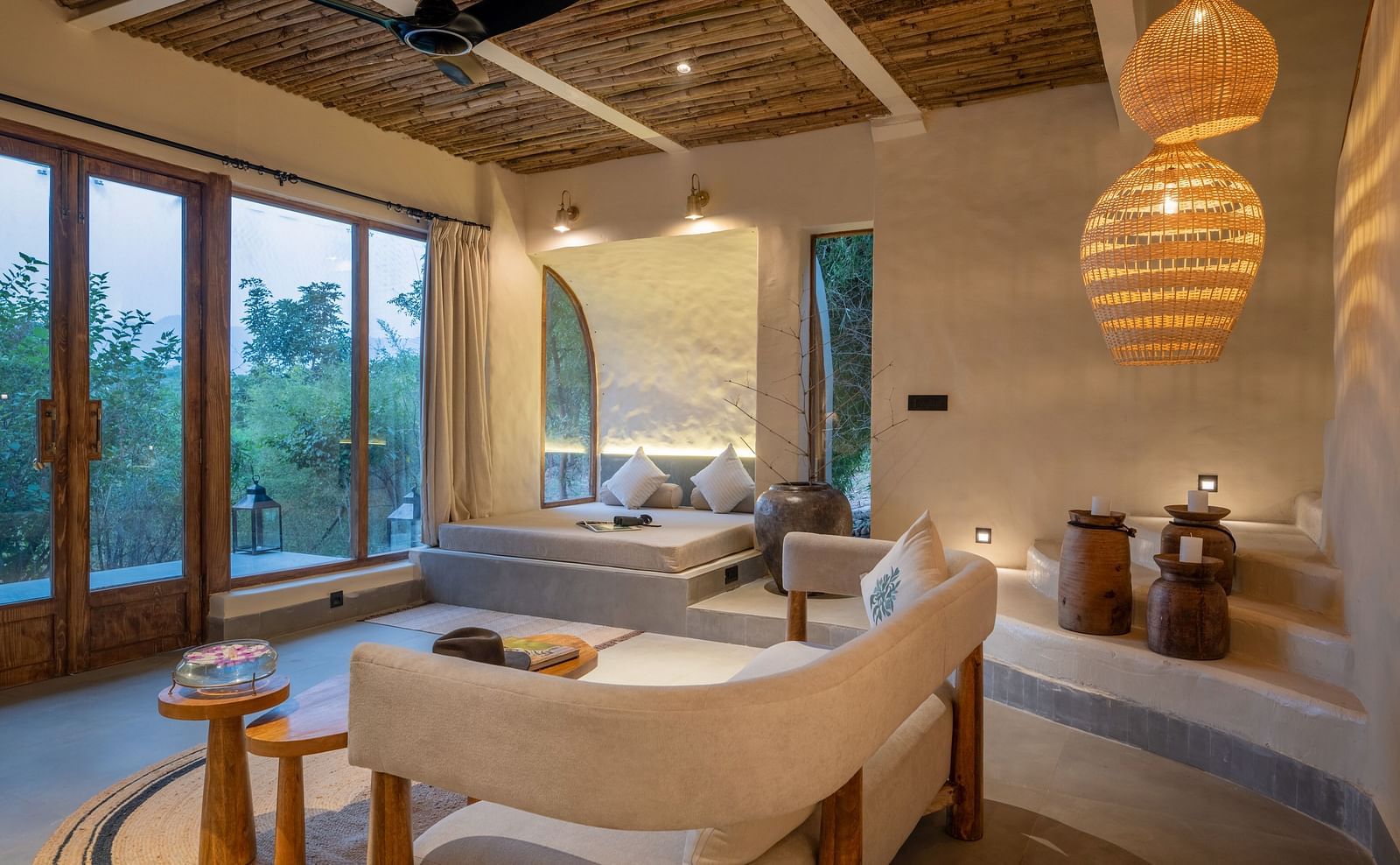 Spacious living room with large windows, woven pendant lights, and earthy decor.