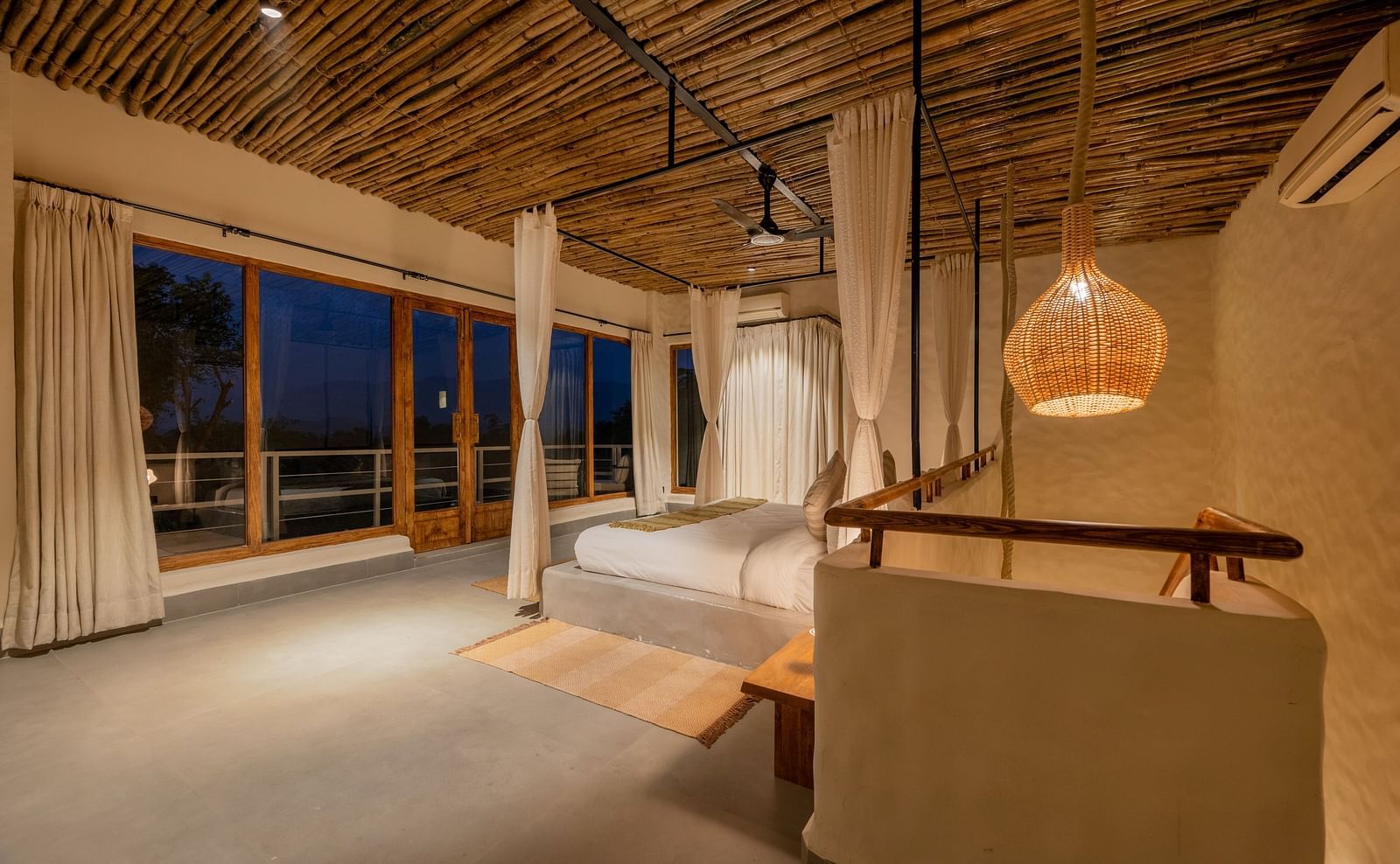 Spacious living room with large windows, woven pendant lights, and earthy decor.