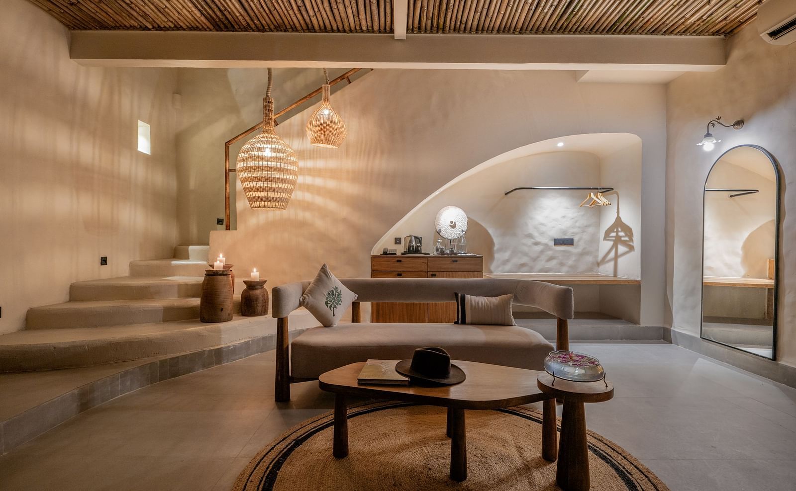 Spacious living room with large windows, woven pendant lights, and earthy decor.
