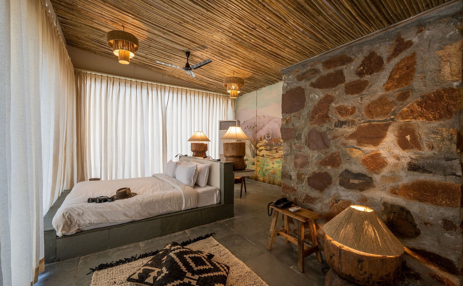 an image of a room with a queen size bed decorative lighting and wall paintings - Utsav Camp Sariska