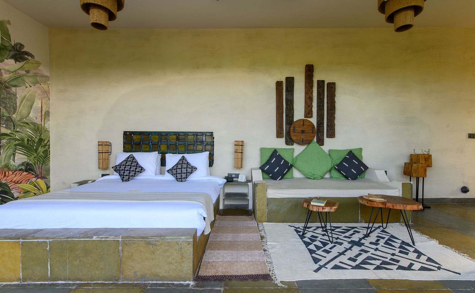 An image of a room with a queen size bed with two decorative chandeliers and other decorative items - Utsav Camp Sariska