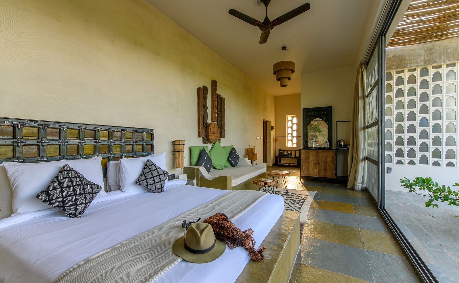 An image of a room with a queen size bed, chandelier, ceiling fan and other decorative items - Utsav Camp Sariska