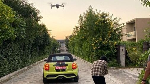 A car, drone and a photographer on a stone pathway - Karma Lakelands.