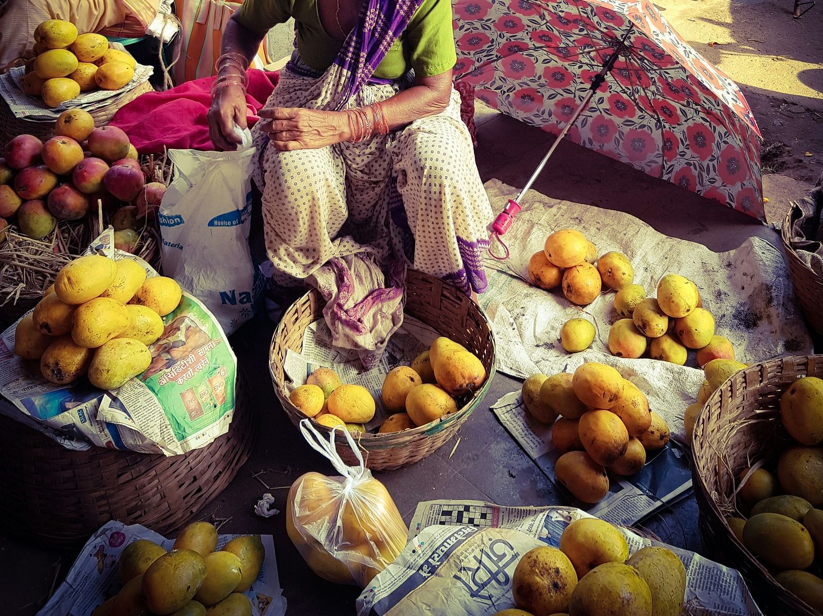 A old street vendor selling mangoes in Mapusa Market
