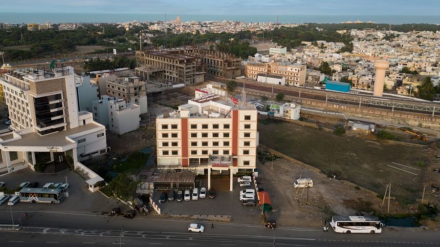 Elevated view of Clarks Collection Somnath and nearby cityscape with buildings, roads, and greenery under a broad sky.