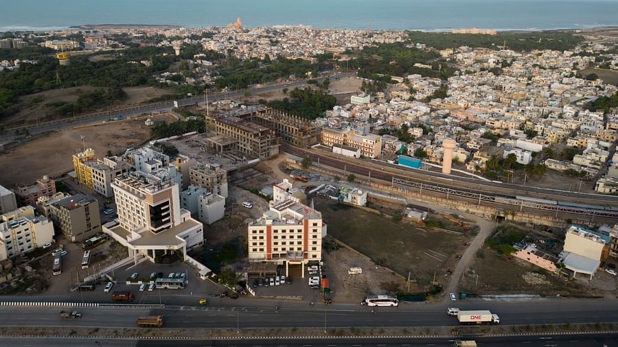 The view of Clarks Collection Somnath amidst surrounding city buildings, open roads, and urban landscape under a bright blue sky.
