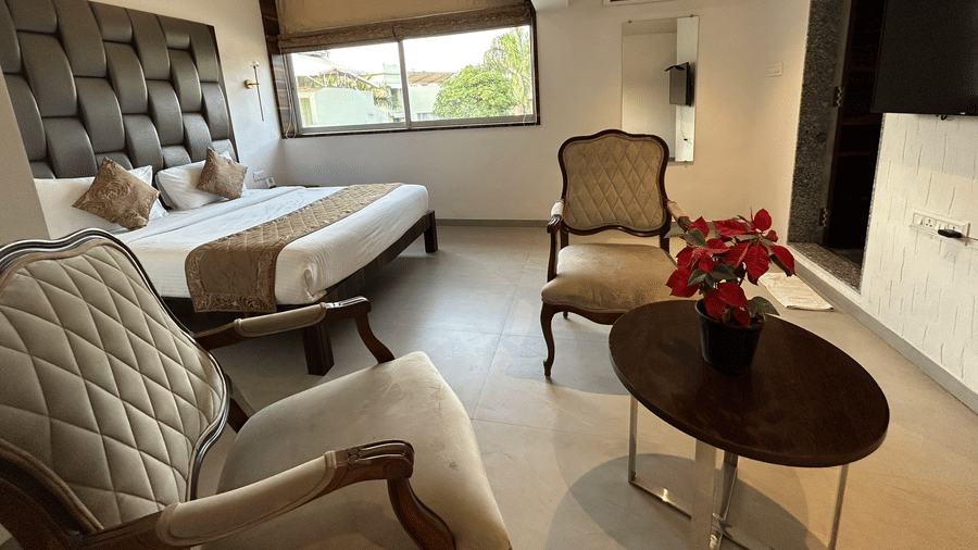 Stylish bed suite with a cushioned headboard, elegant decor, and a cosy seating area – Maxxvalue Klub Klass Villa, Lonavala.