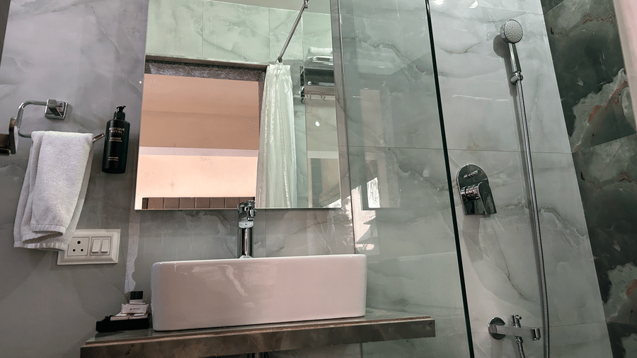 Bathroom with a glass-enclosed shower, sleek marble walls, and premium amenities – Maxxvalue Klub Klass Villa, Lonavala.