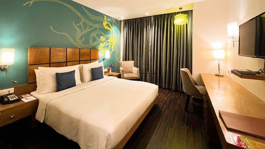 Deluxe Room at The Beatle Hotel, Powai, featuring a modern design with a peacock-themed wall mural.