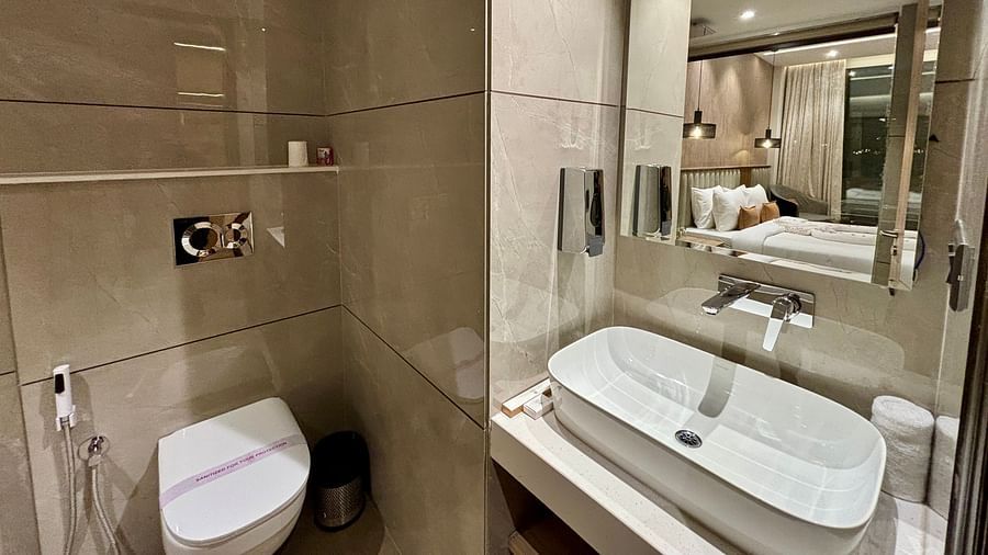 Contemporary bathroom with glass partition, elegant sink, and bathtub – aARNISA Boutique Hotel