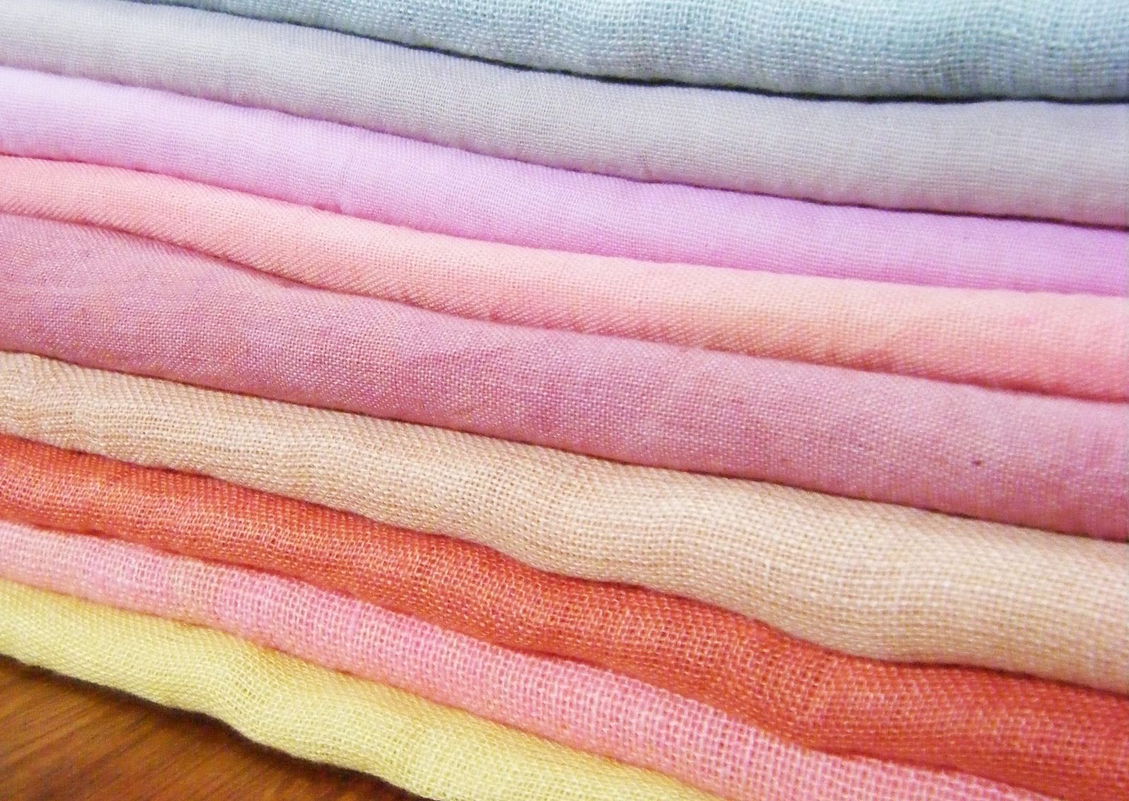 A close up shot of many coloured linen clothes kept on top of each other.