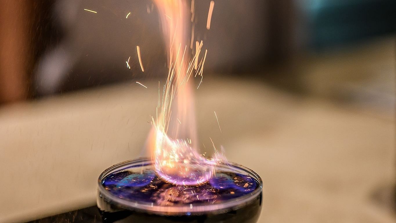Flaming cocktail being prepared, with sparks rising above the glass - Maikhao Dream Villa Resort & Spa, Phuket