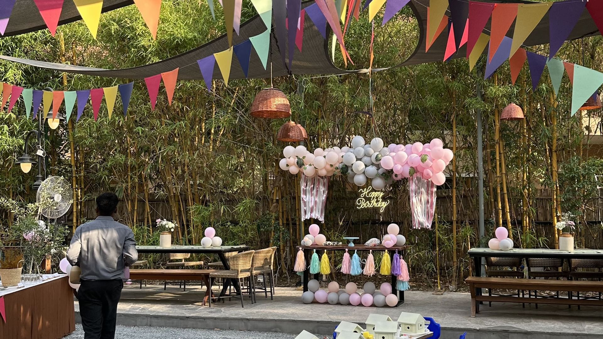 Colorful outdoor dining with hanging flags, long table, and festive setup at Karma Chalets.