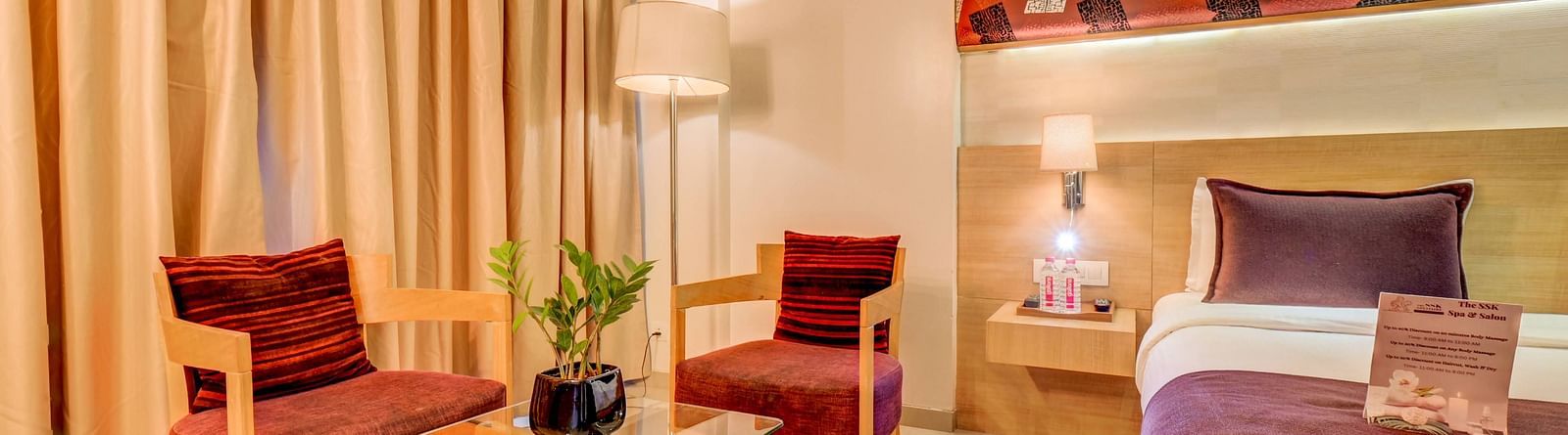a view of the seating area with bed at deluxe room at The SSK Solitaire Hotel & Banquets, Mumbai Naka - Nashik