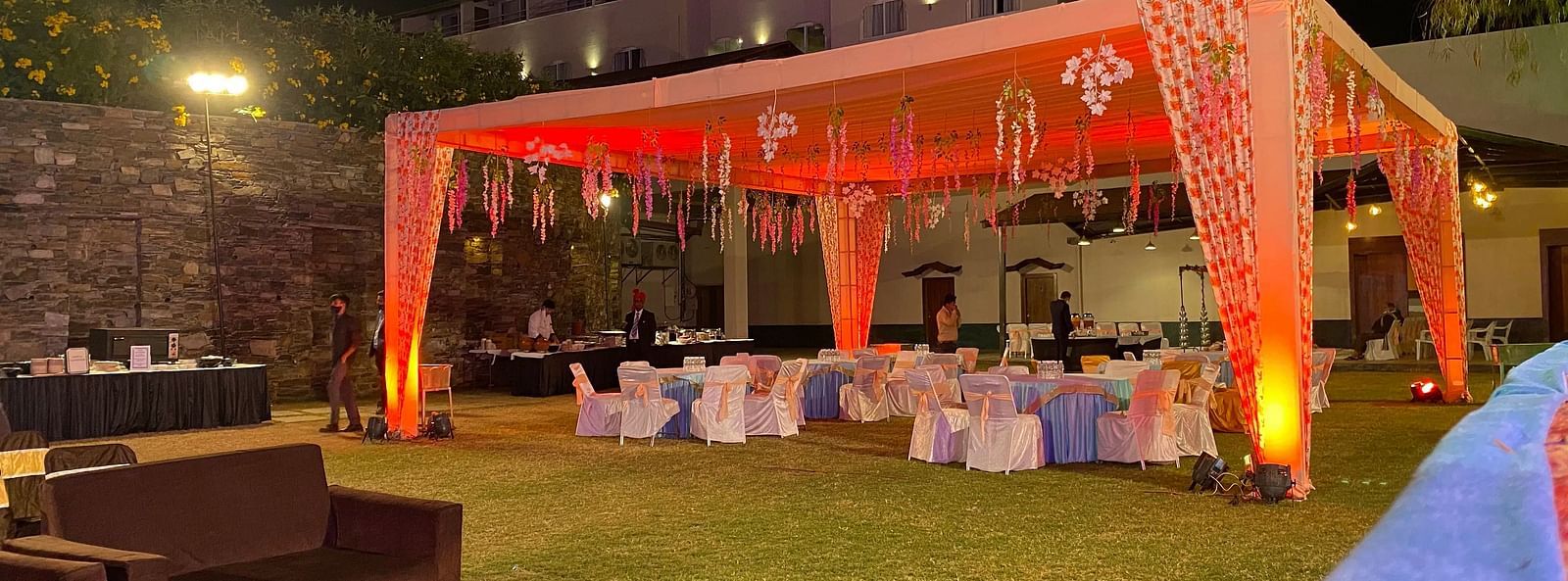 A outdoor event space neatly arranged with a tent, tables and chairs.