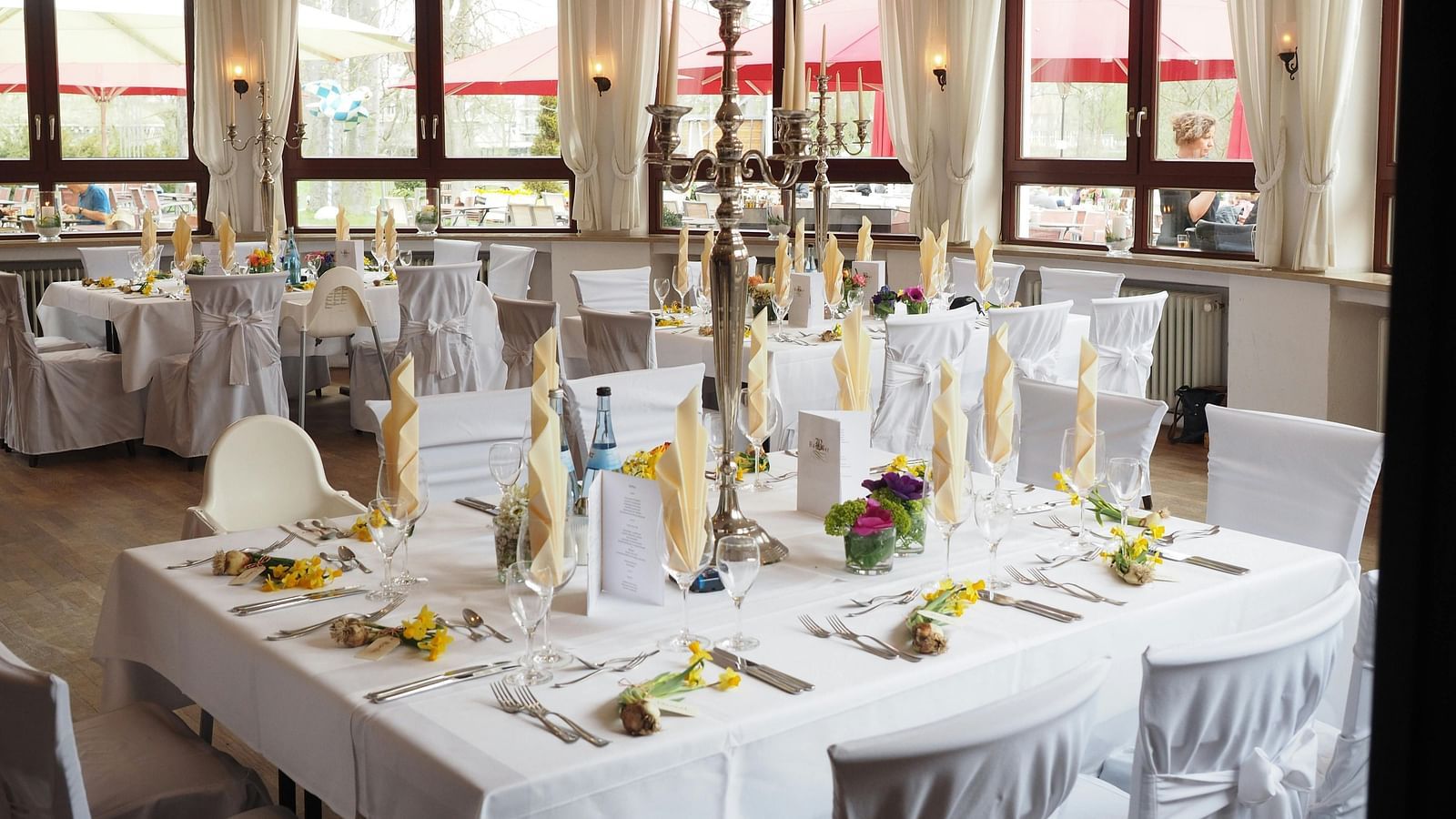 A restaurant depicting seating arrangement with cutlery and decorative items on the table