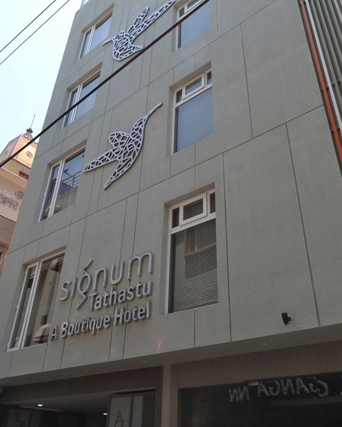 The facade of Signum Tathastu Boutique Hotel, Haridwar, with its hummingbird sculptures above the entrance