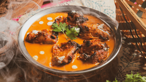 Traditional Indian curry served in a bowl with herbs and spices.