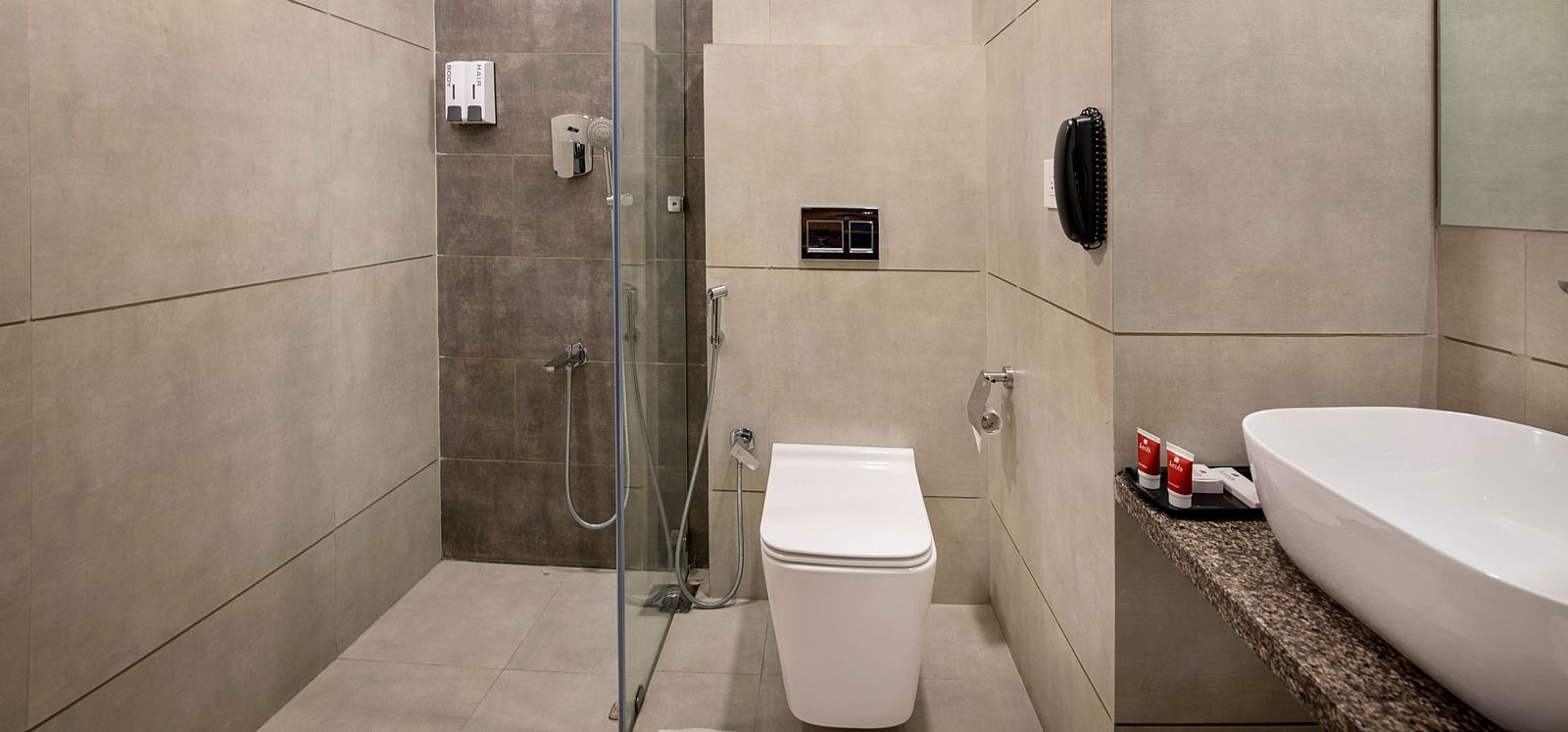 A bathroom with a walk-in shower and sleek fixtures - SK Lords Inn Ahmedabad