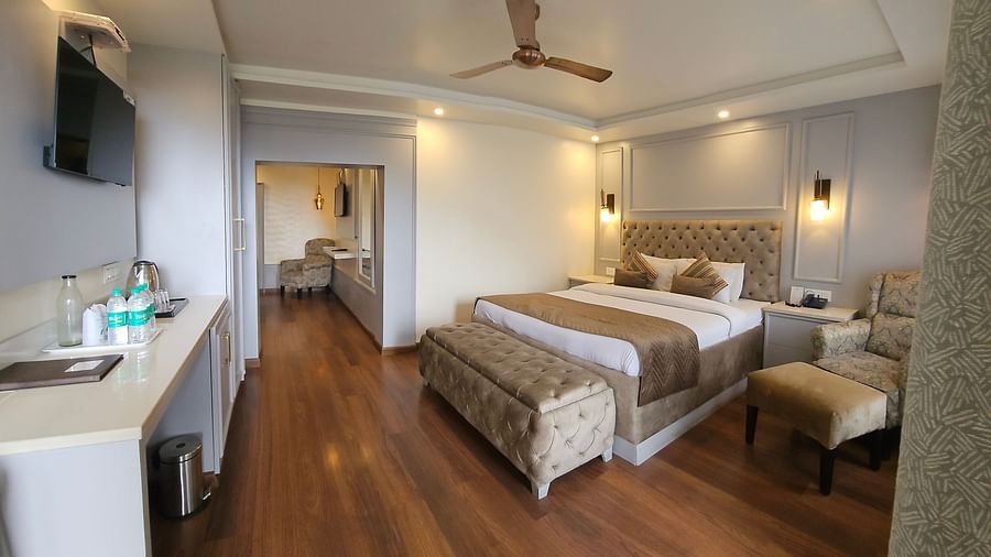 A suite with a plush bed and TV | Mongas Hotel & Resort, Dalhousie