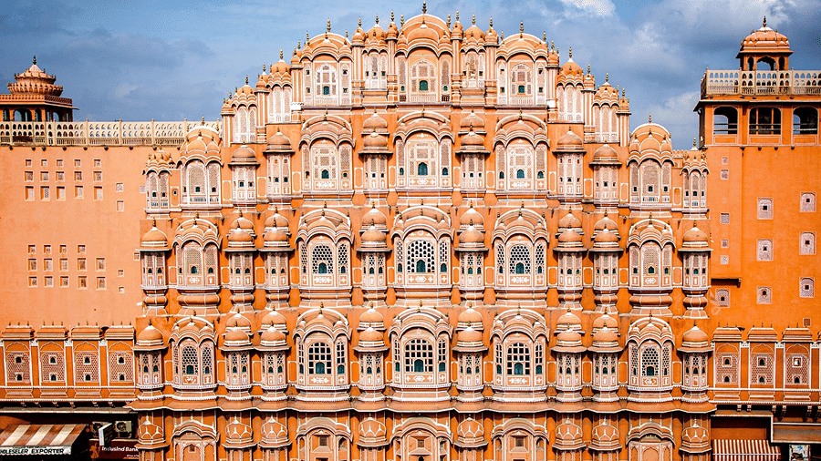 Front view of the pink sandstone facade of Hawa Mahal with hundreds of small latticed windows