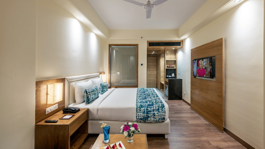 Minimalist club room with twin bed, blue accents, and wooden decor.