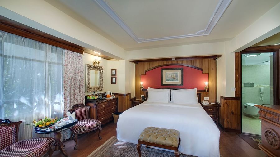 a king size bed and a seating space to its left 1 - Mayfair Hill Resort, Darjeeling