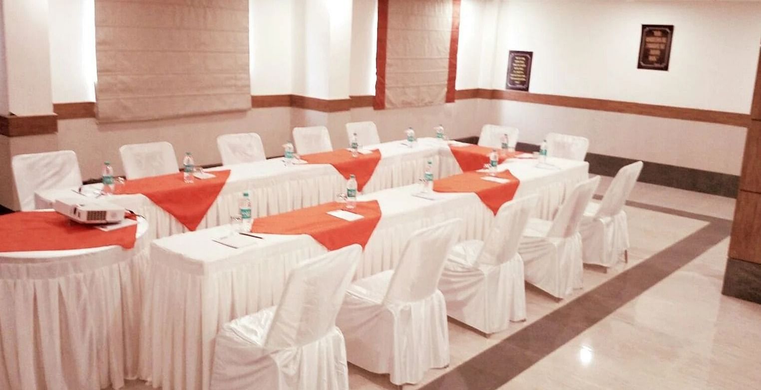 tables and chairs setup in the darbar hall in a boardroom setting - Max Hotel, Jabalpur