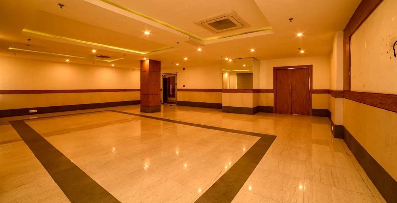 a wide angle shot of our banquet hall with warm lights installed in the false ceiling with central air-conditioning - Max Hotel, Jabalpur