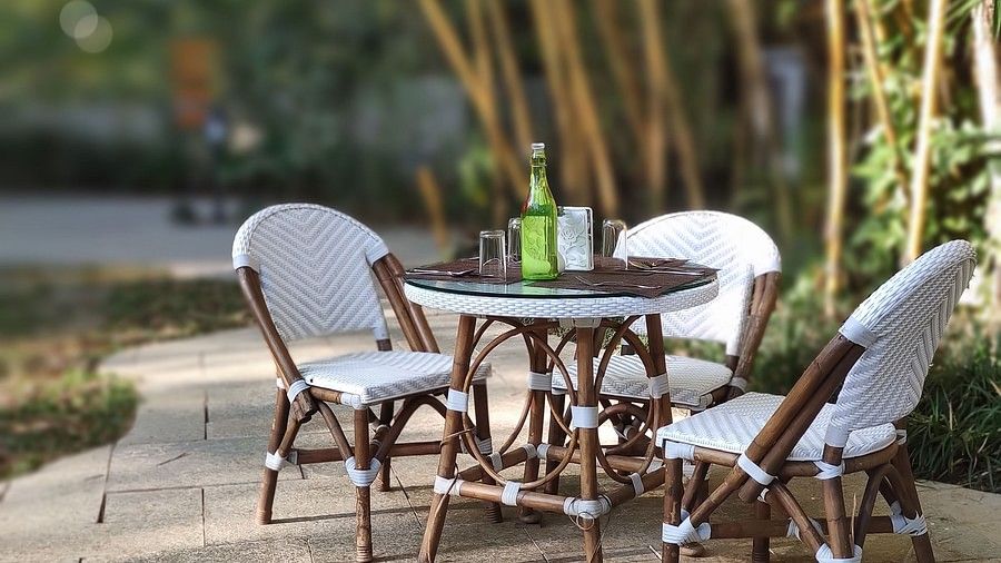 Outdoor patio with chairs and a bottle on the table-Amanvana Spa Resort, Coorg - Luxury Resort