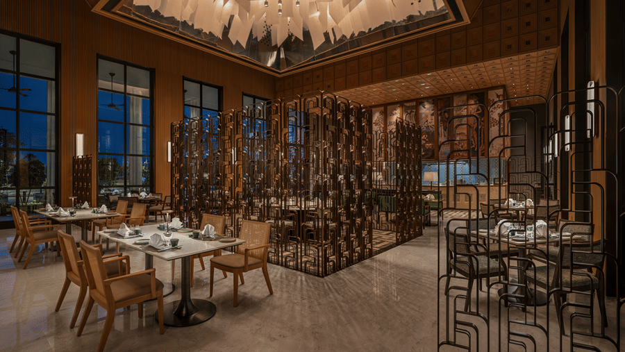 Chin Chin restaurant with cane-backed chairs, laid tables, bronze lattice screens and a suspended paper-sculpture ceiling at The Residency Signature Madurai.