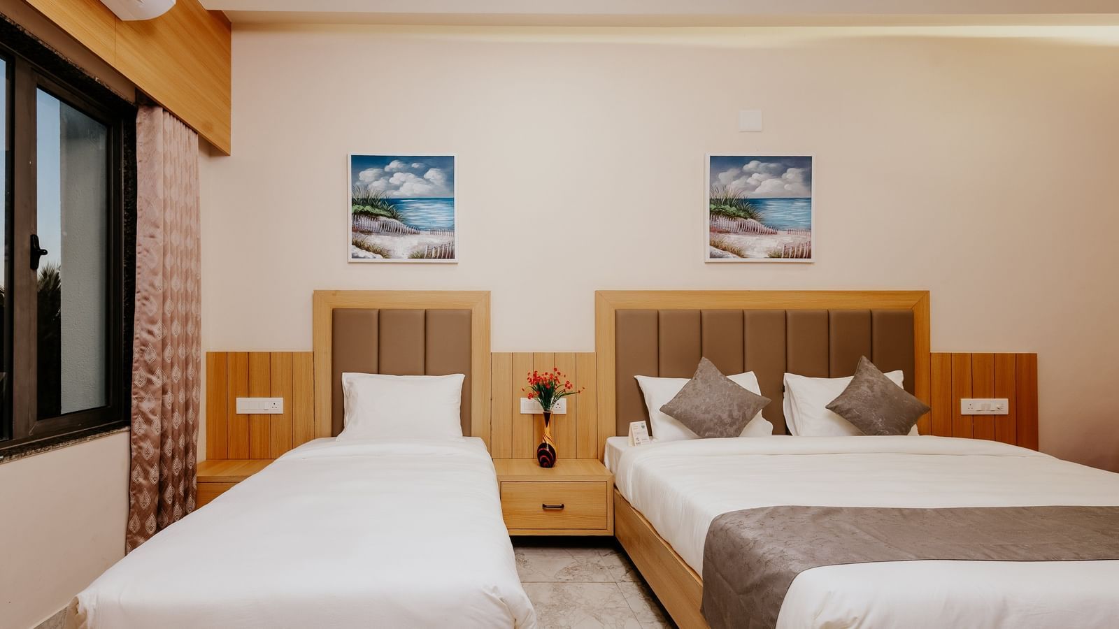 Front view of a well-arranged bedroom at Daksh The Grand Gowardhan, Dwarka, featuring multiple beds and headboards.