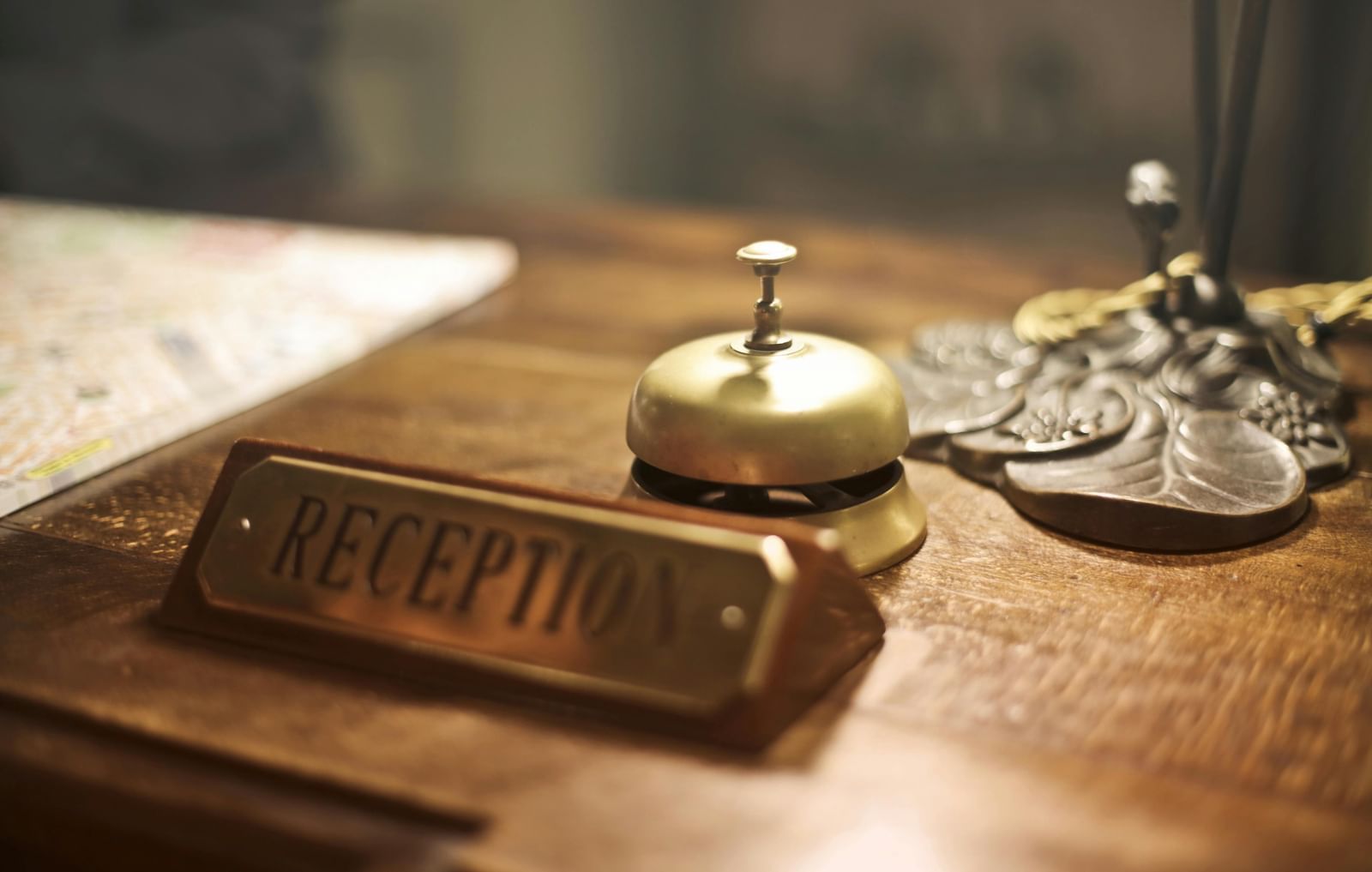 A vintage-style reception desk with a brass bell awaits guests in a charming setting.