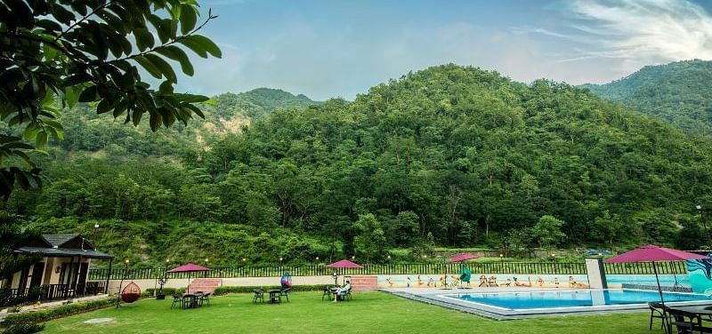 View of the swimming pool during the day at DLS MJ River Resort, Rishikesh.