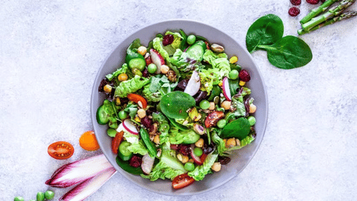 A bowl of salad with various fresh vegetables, symbolizing a healthy and balanced diet.