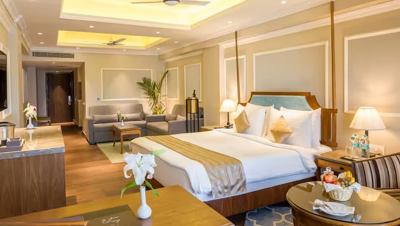 Spacious bed with wooden furniture surrounding the room for storage and relaxation.