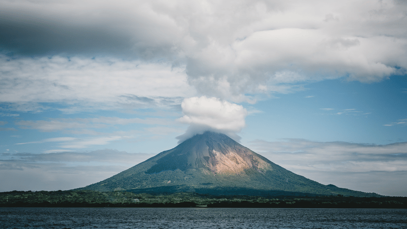 A volcano errupting from a mountain under a hazy sky