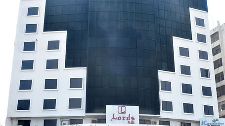 A multi-story building with signage marks the exterior of Lords Plaza Surat.