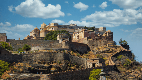 Facade of Kumbhalgarh Fort on a sunny day under a clouded sky